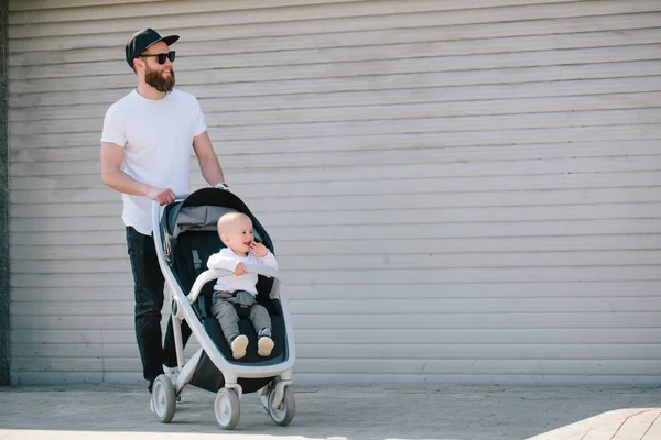 Father walking with a stroller and a baby in the city streets — Stock Photo, Image