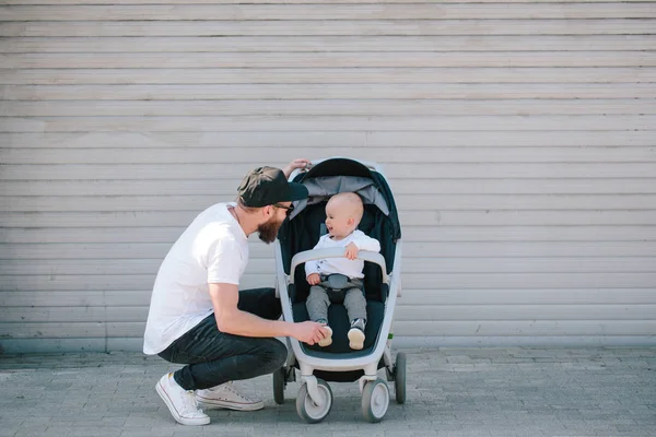 Padre caminando con un carrito y un bebé en las calles de la ciudad —  Fotos de Stock