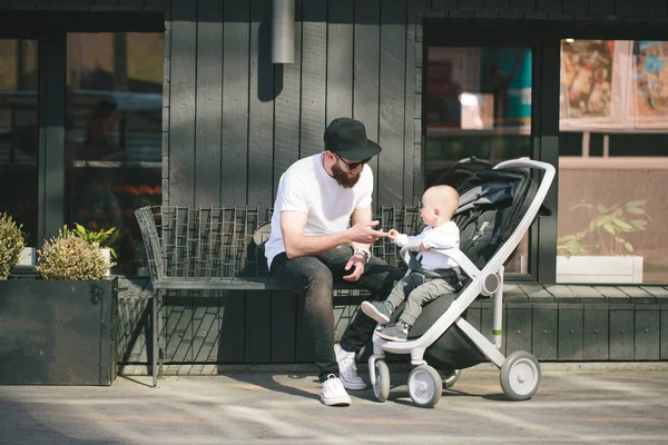 Πατέρα, το περπάτημα με ένα καρότσι και ένα μωρό στους δρόμους της πόλης — Φωτογραφία Αρχείου