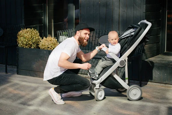 Father walking with a stroller and a baby in the city streets — Stock Photo, Image