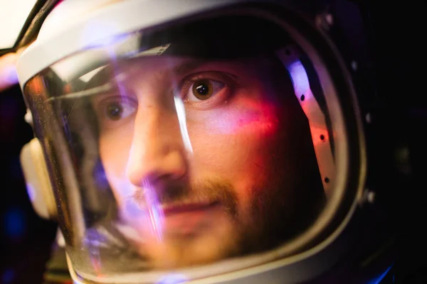 Kasklı bir astronot. Önüne bakıyor. Karanlıkta dünyayı keşfediyor. — Stok fotoğraf
