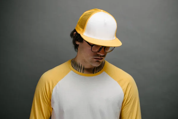Хипстер красивый мужчина модели носить желтую пустую бейсболку с местом для вашего логотипа на сером фоне — стоковое фото