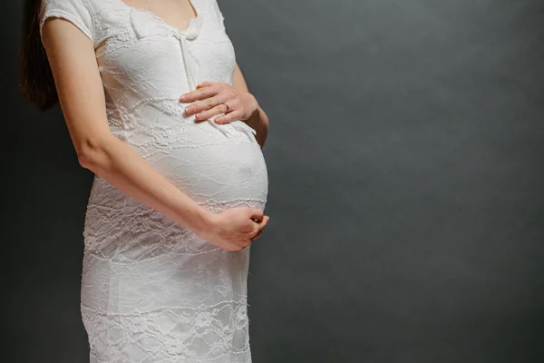 Gravid kvinna porträtt. Hon håller en mage och ler. — Stockfoto