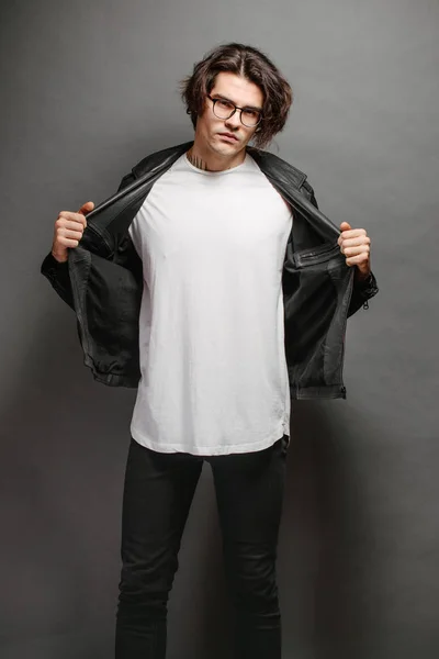 Hipster knap mannelijk model met bril in wit wit wit t-shirt en zwarte jeans met ruimte voor uw logo of ontwerp in casual urban stijl — Stockfoto