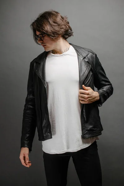 Hipster guapo modelo masculino con gafas en blanco camiseta en blanco y vaqueros negros con espacio para su logotipo o diseño en estilo urbano casual — Foto de Stock