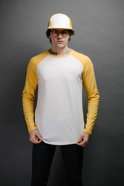 Muž model s vousy na sobě bílé a žluté prázdné Long Sleeve košile pro modelování a baseballová čepice s prostorem pro vaše logo nebo design — Stock fotografie