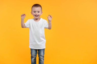 Logon için beyaz tişört giyen çocuk ya da sarı arka plan üzerinde tasarım yapan çocuk.