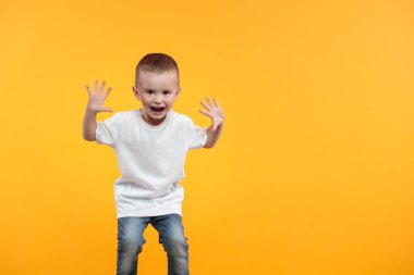 Logon için beyaz tişört giyen çocuk ya da sarı arka plan üzerinde tasarım yapan çocuk.