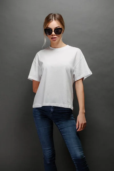 Seksowna kobieta lub dziewczyna ubrana w białą pustą koszulkę z przestrzenią na logo, makieta lub projekt w stylu miejskim casual — Zdjęcie stockowe