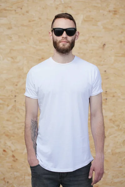 Hipster bel modello maschile con la barba con indosso bianco t-shirt bianca e occhiali da sole e barba con spazio per il vostro logo o design in stile urbano casual — Foto Stock