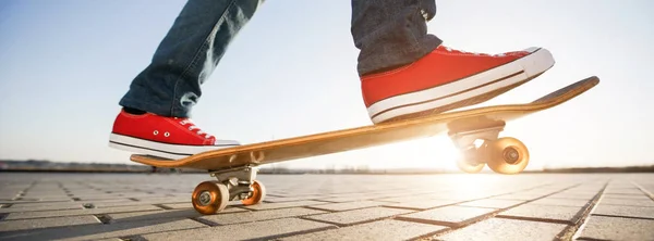 Skater auf einem Skateboard. Ansicht einer Person, die in Freizeitkleidung auf seinem Schlittschuh fährt — Stockfoto