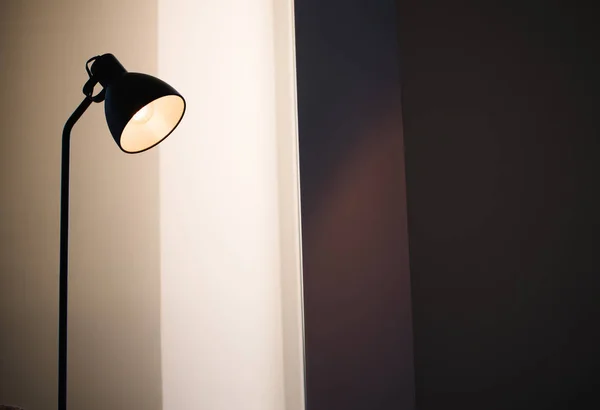 Чорна стояча лампа лофт в інтер'єрі, що сяє з лампою всередині — стокове фото