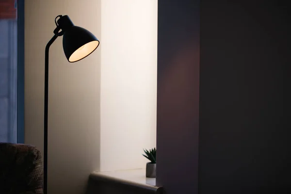 Schwarze Stehleuchte im Innenraum, die mit Edisonbirne im Inneren leuchtet — Stockfoto