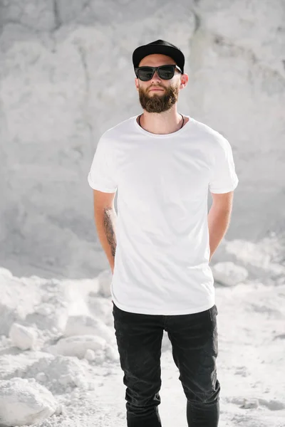 Хипстерская красивая мужская модель с бородой в белой футболке и бейсболке с местом для вашего логотипа или дизайна в стиле casual urban — стоковое фото