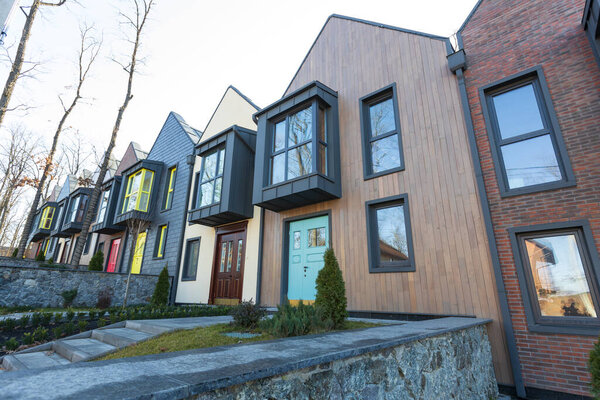 Kiev, Ukraine - February 19, 2020: Modern hi tech townhouses in a residential building settlement with green outdoor facilities in diffrent styles along the road