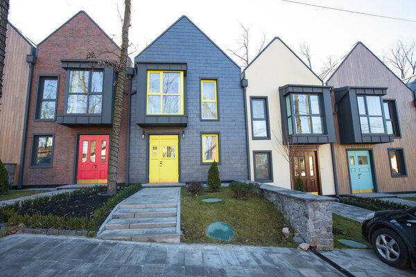 Kiev, Ukraine - February 19, 2020: Modern hi tech townhouses in a residential building settlement with green outdoor facilities in diffrent styles along the road