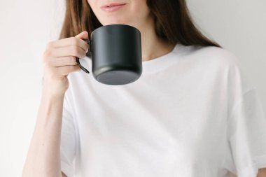 Kadında çay ve kahve için siyah metal bardak, kupa veya kupa için beyaz arkaplan verin.