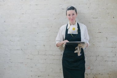 Kendi marangozhanesinde marangoz olarak çalışan kendine güvenen bir kadın. Bir tablet bilgisayar kullanıyor ve çalışma alanındayken notlar yazıyor. Küçük işletme kavramı.