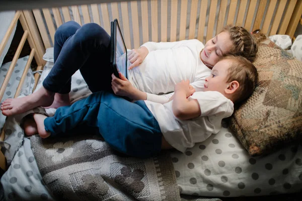 Gyerekek Otthon Nézik Táblagépet Testvérek Egy Tabletet Néznek Füzérrel Ágyukban — Stock Fotó