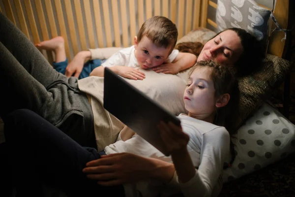 Kinderen Met Moeder Kijken Naar Een Tablet Zitten Bed Met — Stockfoto