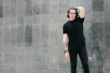 Sakallı, siyah, boş tişörtlü, logonuz için boş yeri olan yakışıklı bir erkek model.