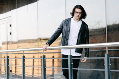 Hippi yakışıklı erkek manken beyaz boş tişört giyiyor. Logonuz için yeri var. Ya da şehir tarzı tasarım.