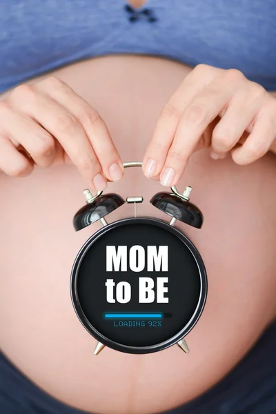 Pregnant woman holding clock — Stock Photo, Image