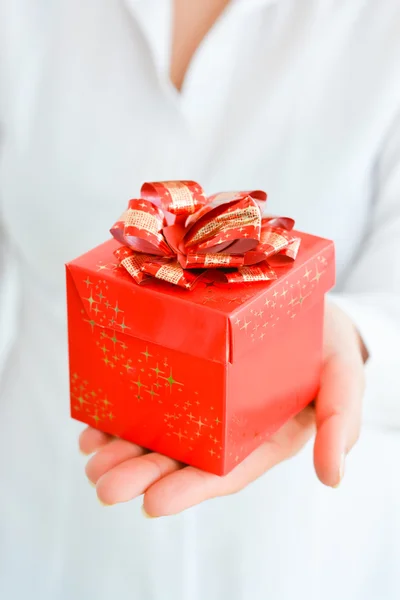 Manos sosteniendo caja de regalo roja —  Fotos de Stock