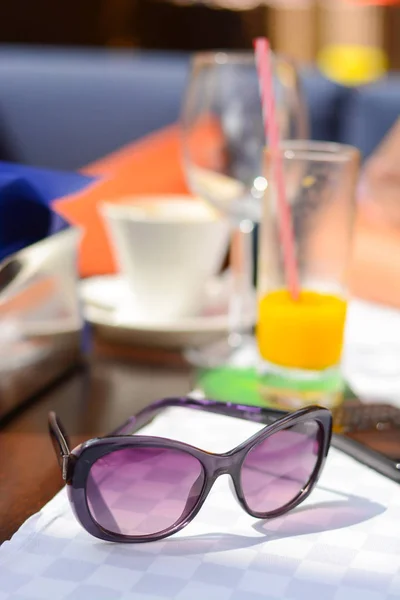 Сонцезахисні окуляри на столі ресторану у відпустці на морській стороні — стокове фото
