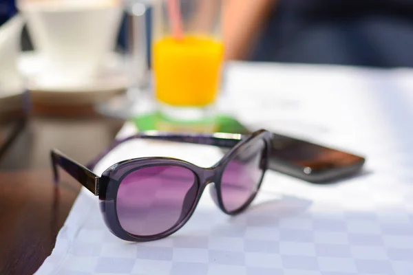 Sonnenbrille auf Restauranttisch im Urlaub am Meer — Stockfoto