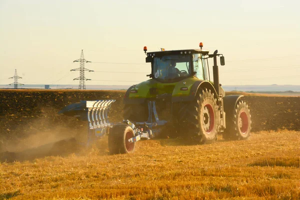 Modernt lantbruk med traktor i plöjde fält — Stockfoto