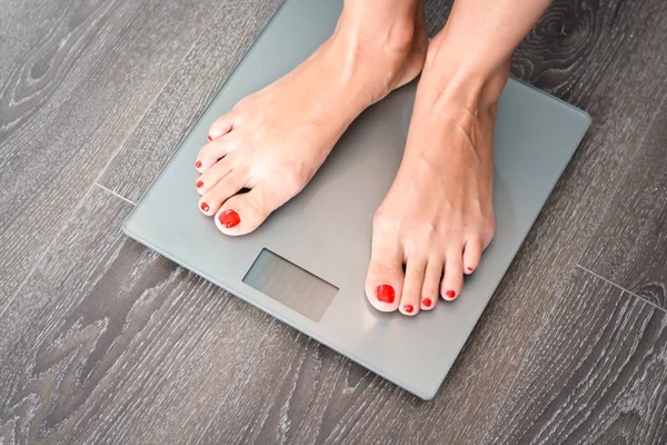 Kost koncept med kvinnors fötter på en skala, viktning själv — Stockfoto