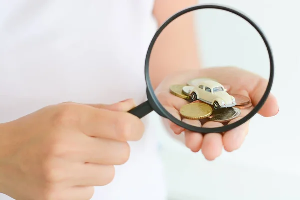 Bilmodell under förstoringsglas i kvinna hand tyder på bil Sök — Stockfoto