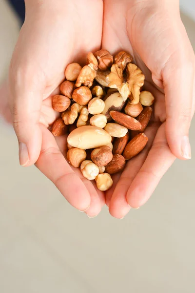 Woman with her hands cupped holding some nuts — Stock Photo, Image