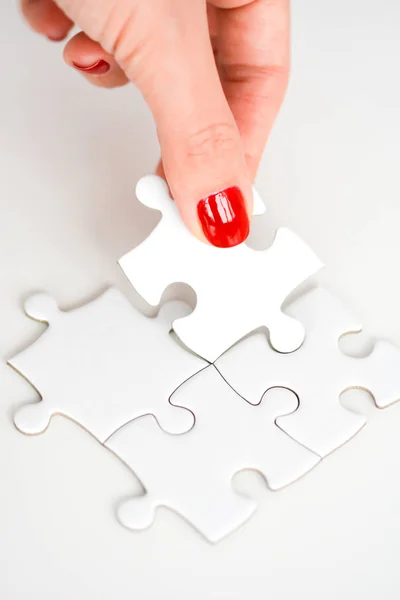 Ręka kobiety dopasowanie odpowiedniego fragmentu puzzle sugeruje koncepcja sieci biznesowych — Zdjęcie stockowe