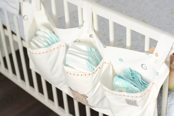 Pile or stack of diapers in baby bed hanging storage bag