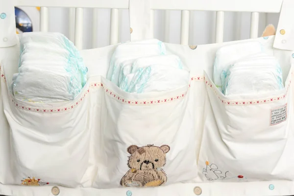 Pila o pila de pañales en la cama de bebé colgando bolsa de almacenamiento — Foto de Stock