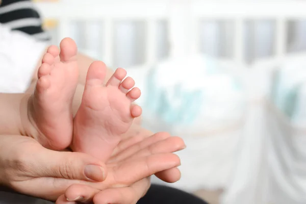 Mother holding baby feet in her palms — Stock Photo, Image