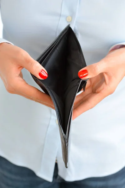 Woman holding an empty wallet suggesting bankruptcy