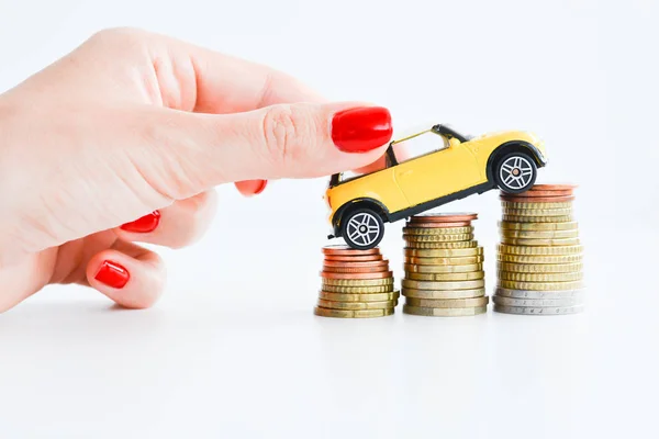 Subir amarillo coche en la pila de monedas que sugiere el aumento de la tendencia de ventas — Foto de Stock