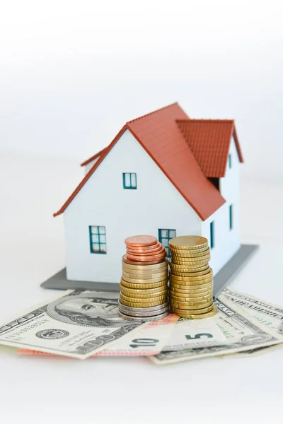 Klassiek huis model met stapel van munten geïsoleerd op witte achtergrond — Stockfoto