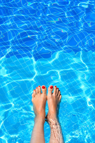 Mulher pés na piscina em um dia quente de verão — Fotografia de Stock