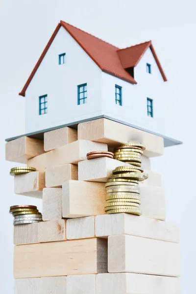 Precios inmobiliarios o concepto de crisis con casa en pila de palos de madera — Foto de Stock