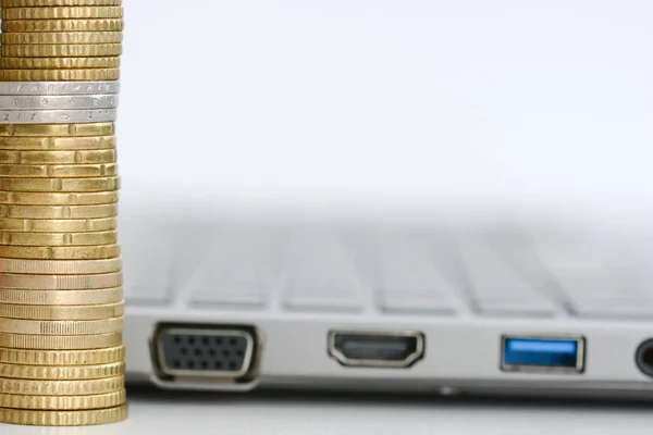 Stack or pile of coins and a laptop keyboard — Stock Photo, Image