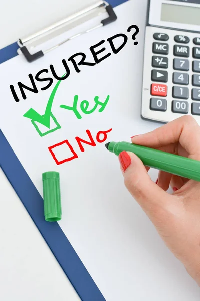 Ja eller nej fråga om försäkringen med miniräknare och grön penna — Stockfoto