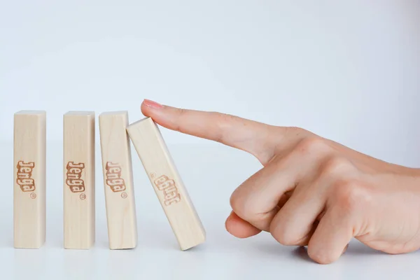 Menselijke hand een domino-effect concept beginnen met houten blokken — Stockfoto