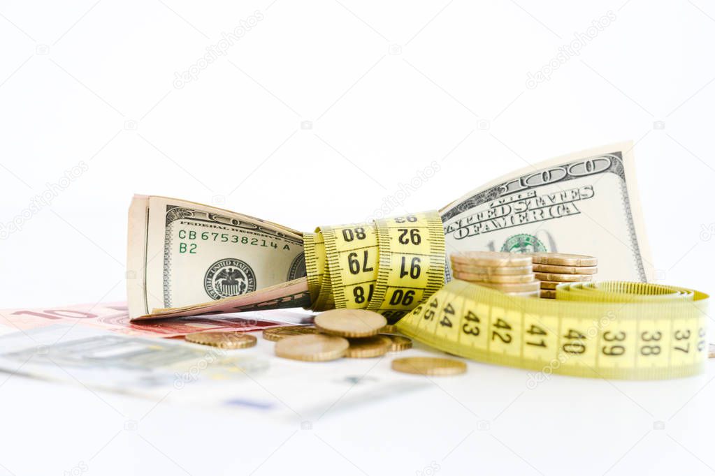 Dollar bills tied up with measuring tape suggesting measurement of financial success