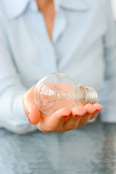 Affärskvinna som håller i handen en glödlampa — Stockfoto