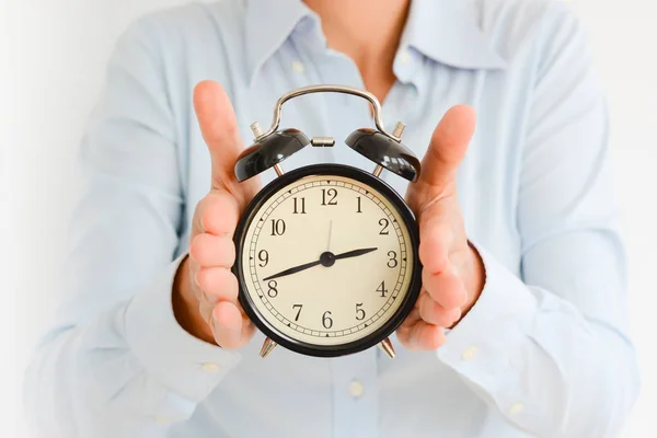 Geschäftsfrau hält eine alte Uhr in der Hand und deutet Deadline-Konzept an — Stockfoto
