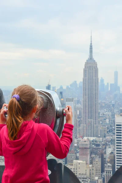 Mała dziewczynka oglądając nowojorskiego Empire State Building w widokiem na miasto pkt — Zdjęcie stockowe